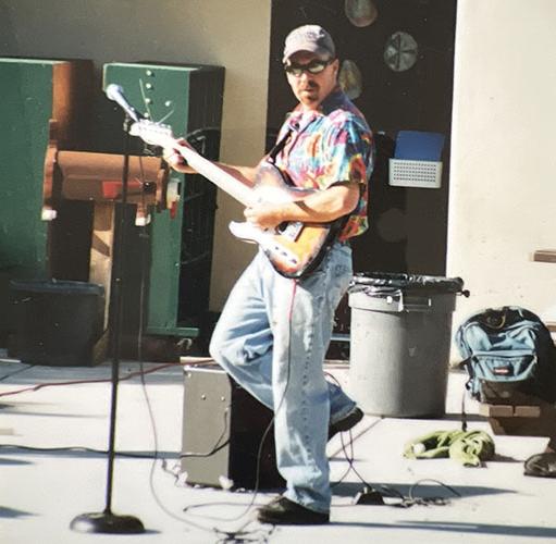 穿着彩色衬衫的男人在弹电吉他