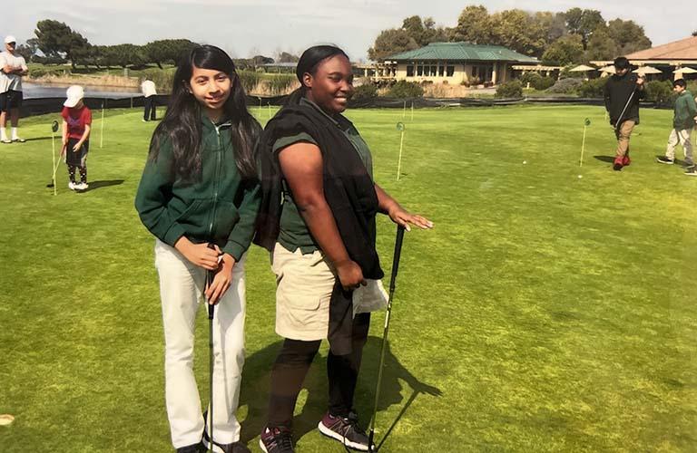 两个中学女生在高尔夫球场上